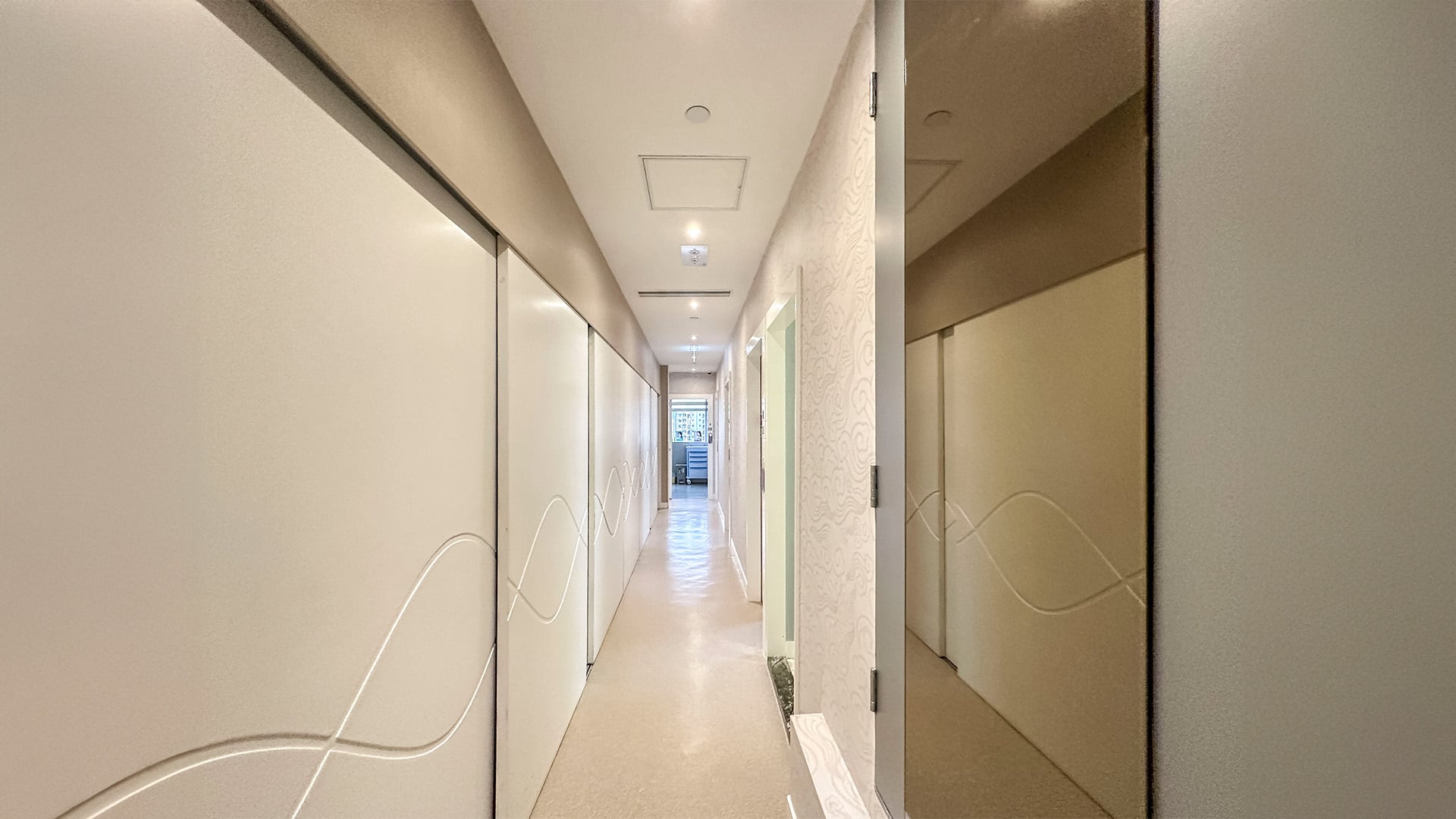 寬敞的美容中心等候區，配有白色沙發和冷凍溶脂設備的宣傳牆，突顯舒適與專業的氛圍。