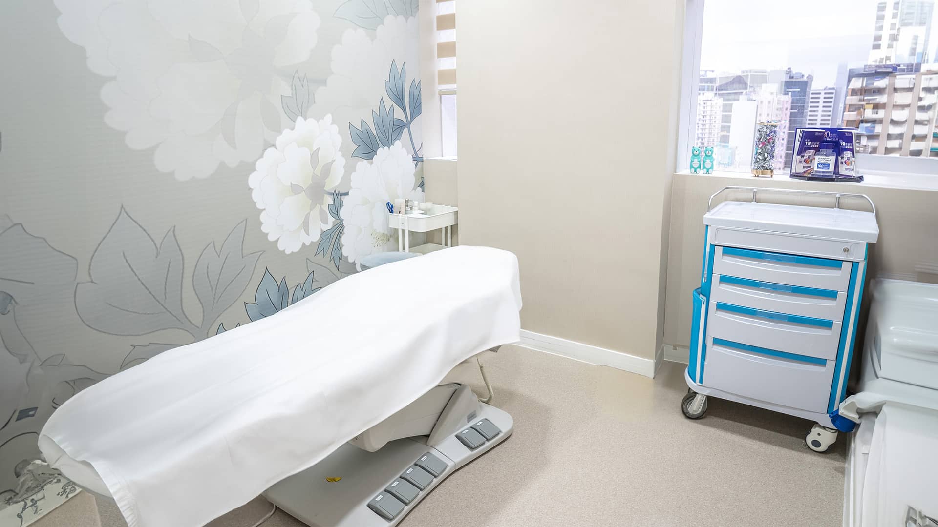 寬敞的美容中心等候區，配有白色沙發和冷凍溶脂設備的宣傳牆，突顯舒適與專業的氛圍。